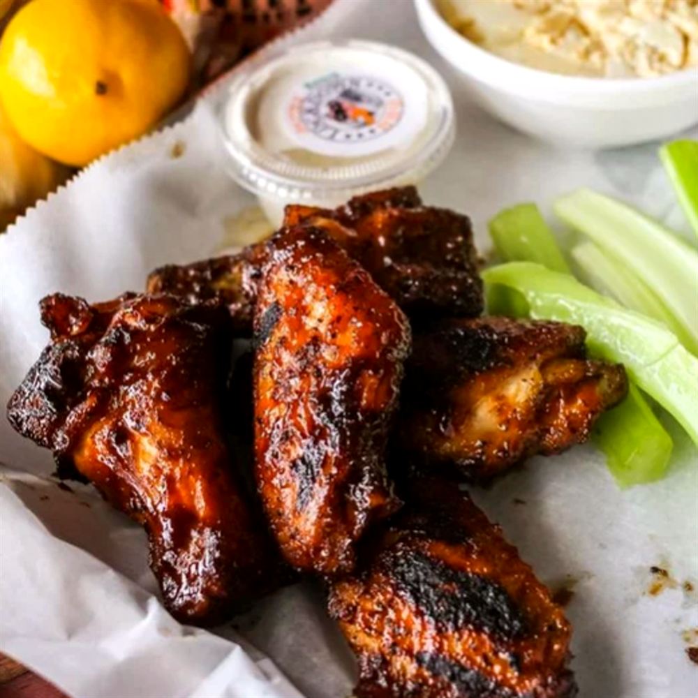 Smoked chicken wings with celery and a cup of house sauce